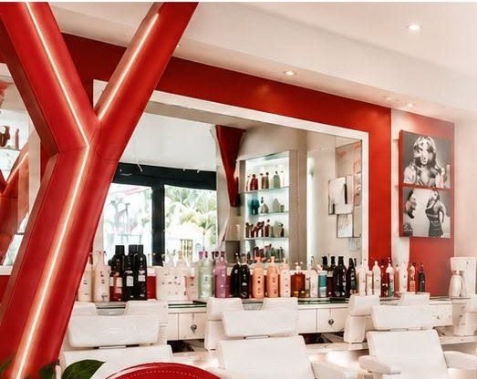 Intérieur du salon Technicity : fauteuils blancs, murs rouges et étagères de produits